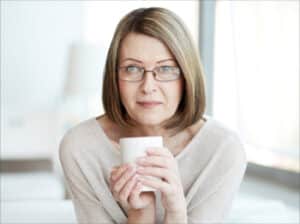 older women wearing glasses holding coffee cup