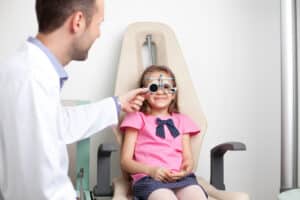 a young girl receiving a childrens eye exam from a pediatric ophthalmologist in cleveland.